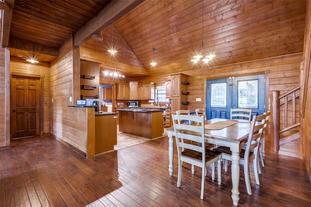 dining space featuring hardwood / wood-style floors, high vaulted ceiling, beamed ceiling, and wooden walls