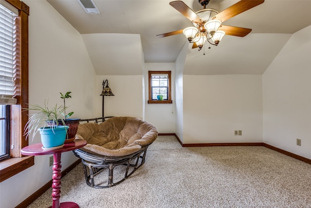 carpeted living room with ceiling fan and lofted ceiling