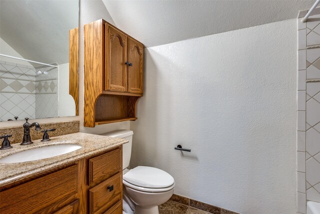 bathroom featuring vanity, toilet, and tiled shower