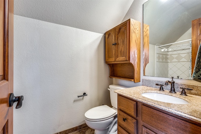 bathroom featuring vanity, vaulted ceiling, a shower, and toilet