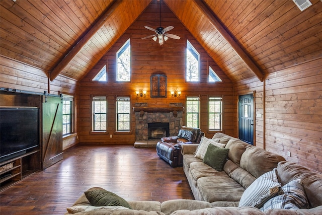 living room with a stone fireplace, dark hardwood / wood-style flooring, and a wealth of natural light