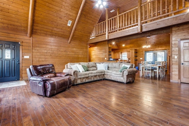 living room featuring high vaulted ceiling, wooden walls, hardwood / wood-style floors, and wood ceiling