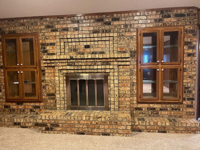 room details with a fireplace, carpet floors, and a textured ceiling