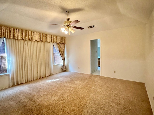 carpeted empty room with ceiling fan and a textured ceiling