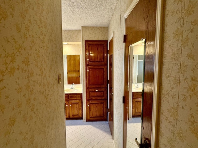 hallway featuring a textured ceiling and sink