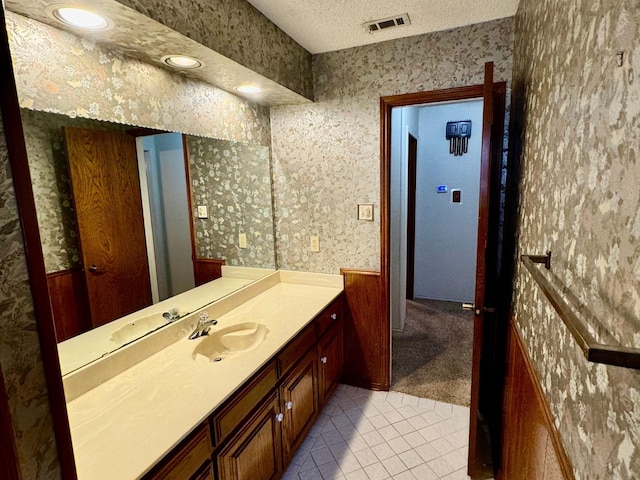 bathroom featuring tile patterned floors, vanity, and a textured ceiling