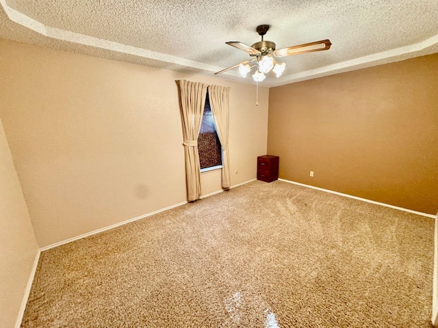 carpeted spare room featuring a textured ceiling and ceiling fan