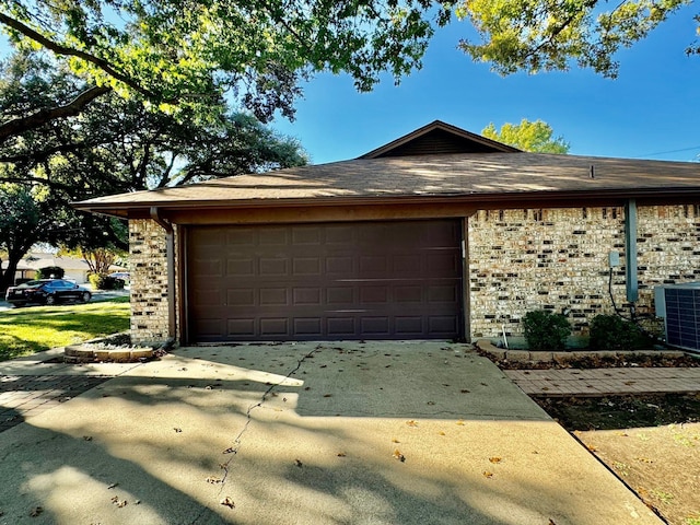 exterior space with central AC unit and a garage