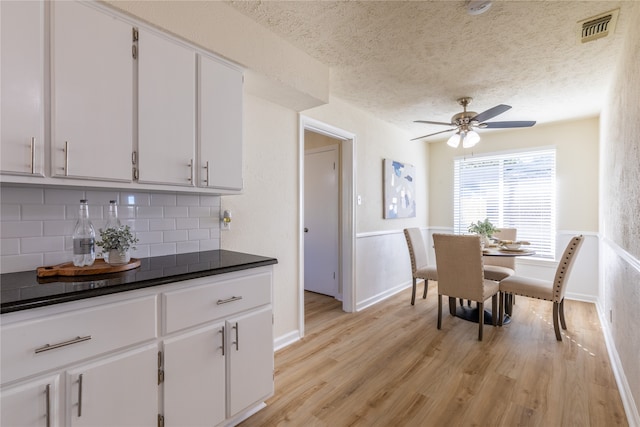 dining space featuring a textured ceiling, light wood-type flooring, and ceiling fan