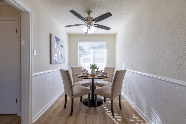 dining area with ceiling fan, a textured ceiling, and light wood-type flooring