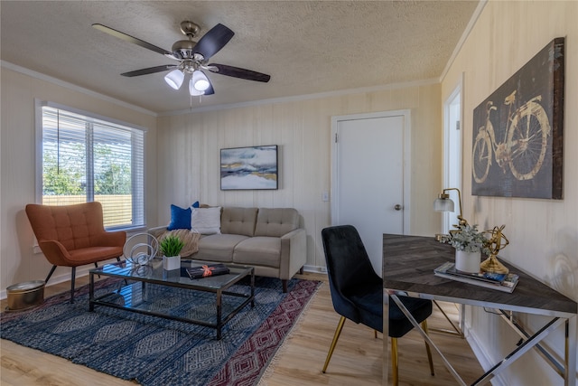 living room featuring hardwood / wood-style floors, a textured ceiling, ceiling fan, and ornamental molding