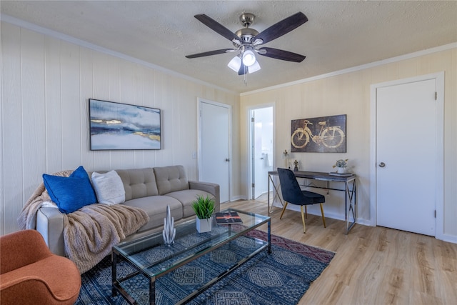 living room featuring a textured ceiling, light wood-type flooring, and crown molding