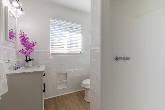 bathroom featuring hardwood / wood-style floors, vanity, toilet, and tile walls