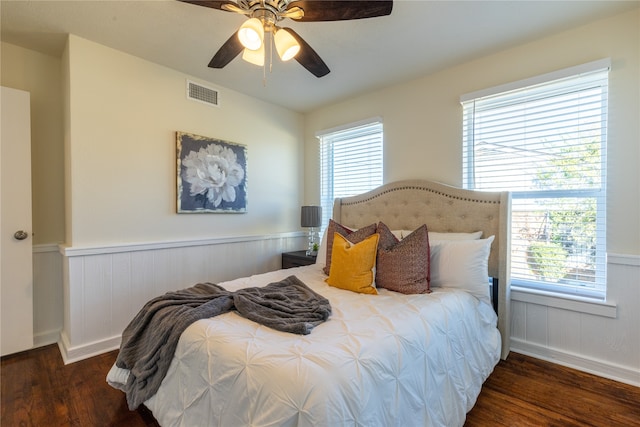 bedroom with ceiling fan, dark hardwood / wood-style floors, and multiple windows