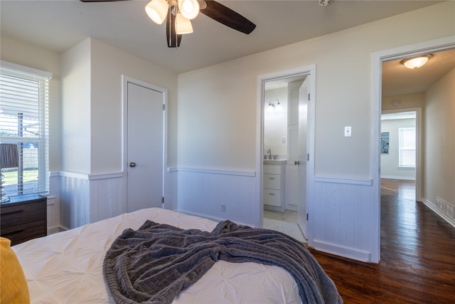 bedroom featuring connected bathroom, ceiling fan, and dark hardwood / wood-style flooring