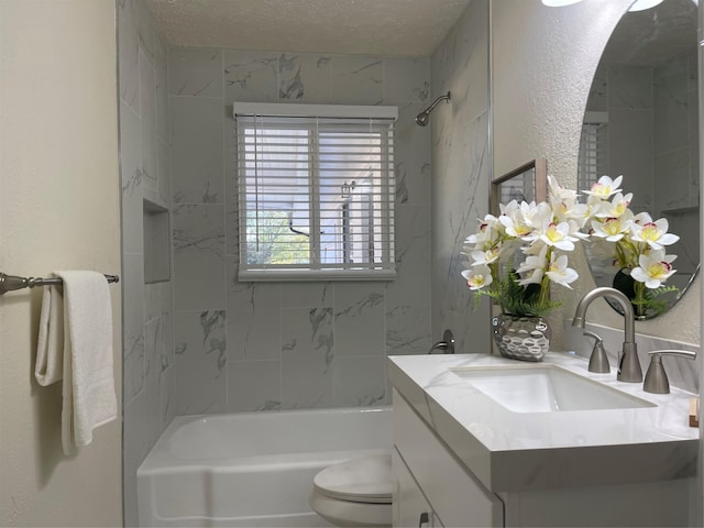 full bathroom with vanity, a textured ceiling, tiled shower / bath combo, and toilet