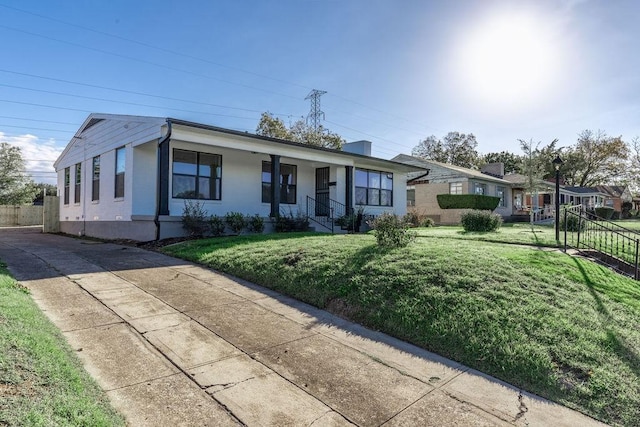 ranch-style house featuring covered porch and a front lawn