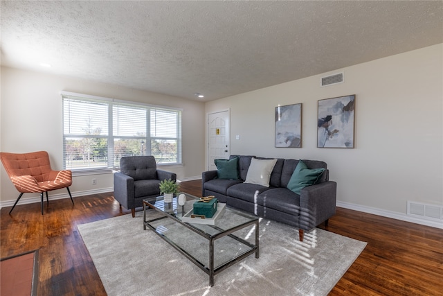 living room with dark hardwood / wood-style flooring and a textured ceiling