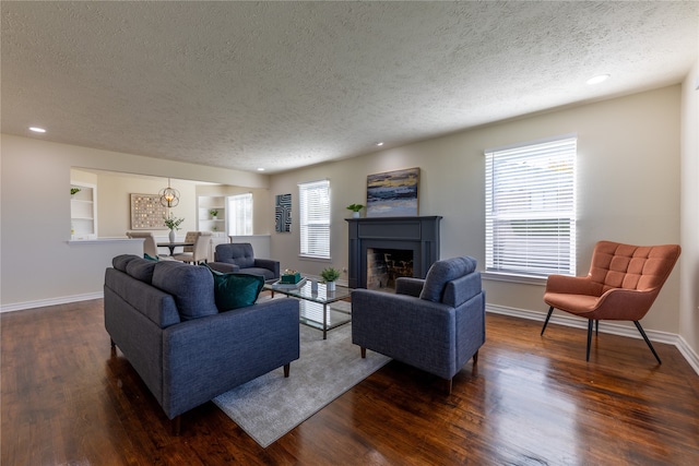 living room featuring dark hardwood / wood-style flooring, a textured ceiling, and a wealth of natural light