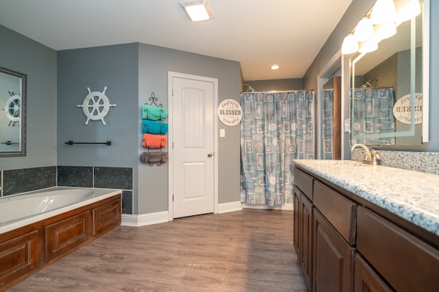 bathroom with a bathtub, vanity, and hardwood / wood-style flooring