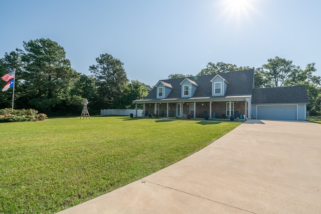 cape cod house featuring covered porch, a garage, and a front yard