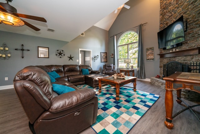 living room with ceiling fan, a fireplace, high vaulted ceiling, and dark wood-type flooring