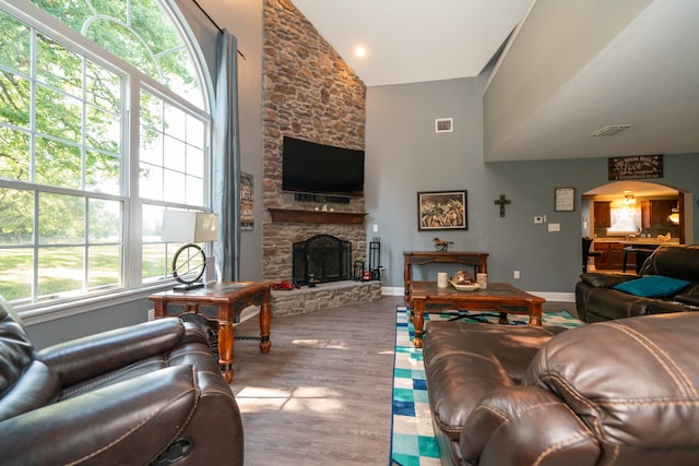 living room with a fireplace, hardwood / wood-style floors, and high vaulted ceiling