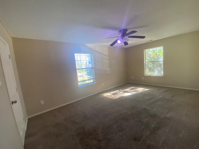 carpeted spare room featuring plenty of natural light and ceiling fan