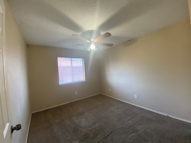 carpeted empty room with ceiling fan and a textured ceiling