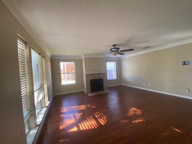 unfurnished living room with a wealth of natural light, dark wood-type flooring, and ceiling fan