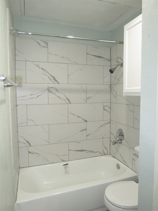 bathroom with tiled shower / bath combo and toilet