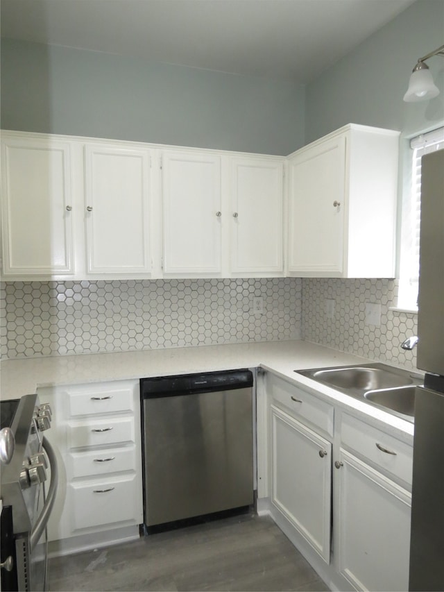 kitchen with dark hardwood / wood-style flooring, tasteful backsplash, stainless steel appliances, sink, and white cabinets