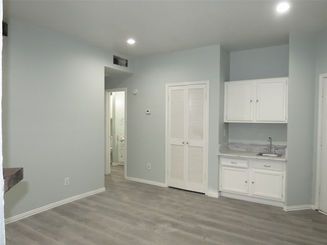 kitchen featuring white cabinets, light hardwood / wood-style floors, and sink