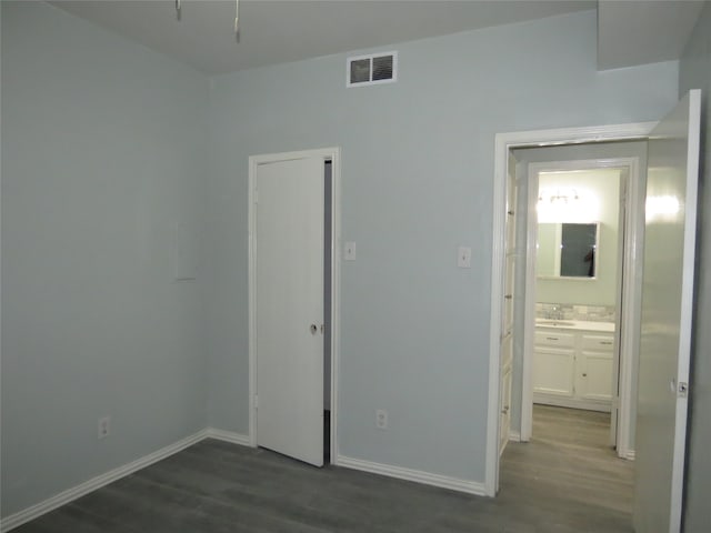 unfurnished bedroom with sink and dark hardwood / wood-style floors