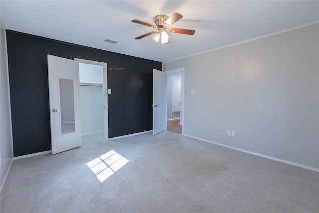 unfurnished bedroom with light colored carpet, ceiling fan, and crown molding