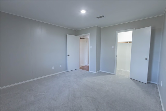 unfurnished bedroom with light colored carpet, a closet, and crown molding