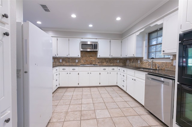 kitchen with stainless steel appliances, crown molding, sink, light tile patterned floors, and white cabinetry