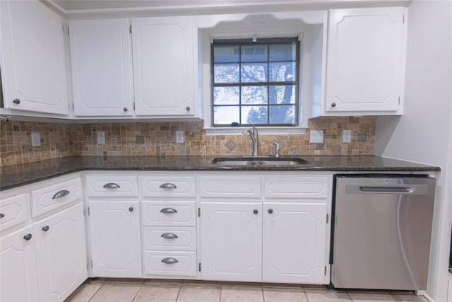 kitchen with dark stone countertops, sink, white cabinets, and stainless steel dishwasher