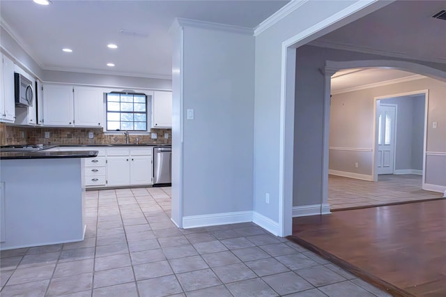 kitchen featuring white cabinets, crown molding, sink, light tile patterned floors, and stainless steel appliances