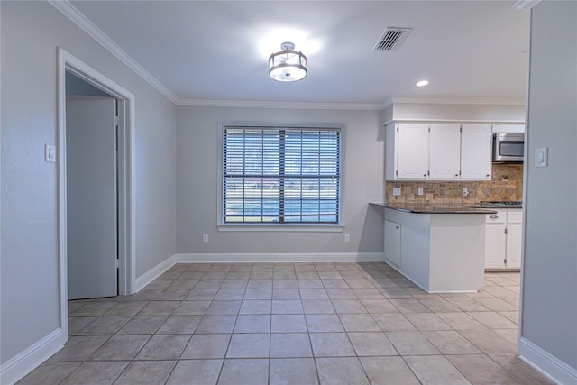 kitchen featuring crown molding, light tile patterned floors, tasteful backsplash, white cabinetry, and kitchen peninsula