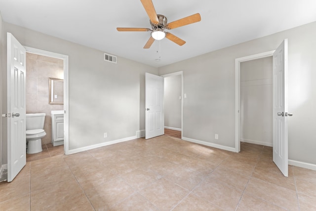 unfurnished bedroom featuring ceiling fan, a closet, ensuite bath, and light tile patterned floors