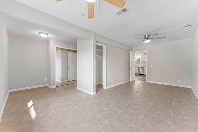 interior space with ceiling fan, visible vents, and baseboards