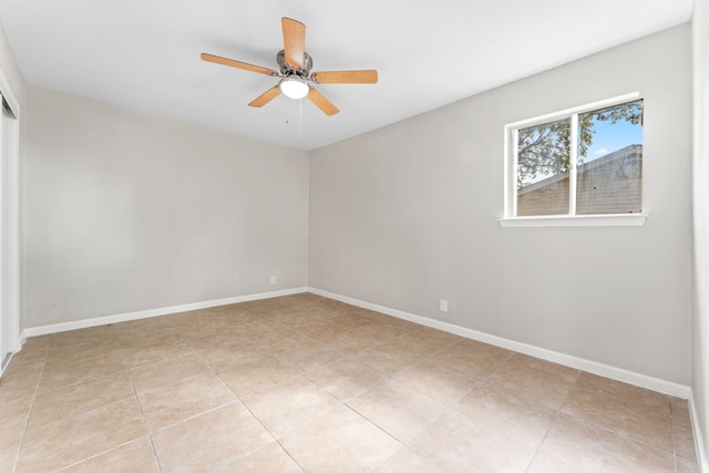 empty room with ceiling fan and baseboards