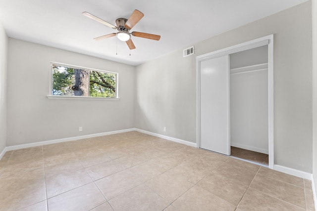 unfurnished bedroom featuring ceiling fan, a closet, and light tile patterned floors