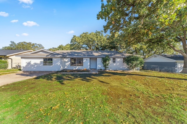 ranch-style home featuring fence, driveway, and a front lawn