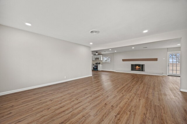 unfurnished living room featuring ceiling fan and light hardwood / wood-style flooring