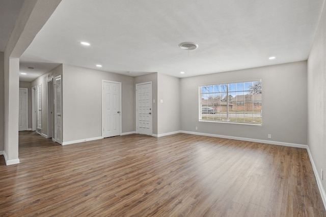 unfurnished room with baseboards, wood finished floors, and recessed lighting