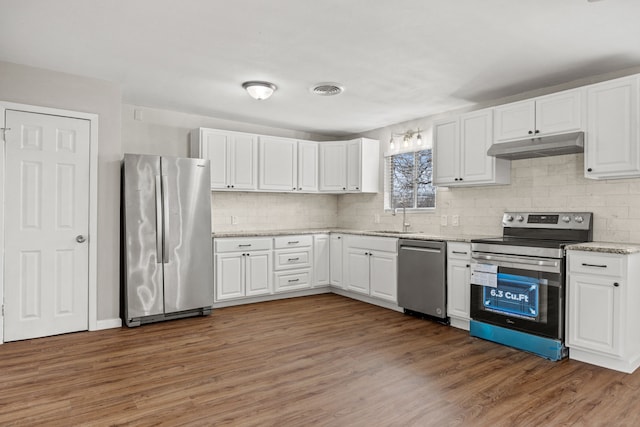 kitchen with visible vents, appliances with stainless steel finishes, white cabinets, a sink, and under cabinet range hood