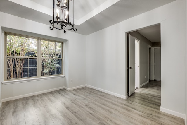 empty room featuring light hardwood / wood-style floors and an inviting chandelier