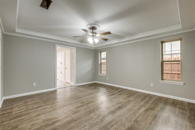 unfurnished room with a tray ceiling, hardwood / wood-style flooring, ornamental molding, and ceiling fan